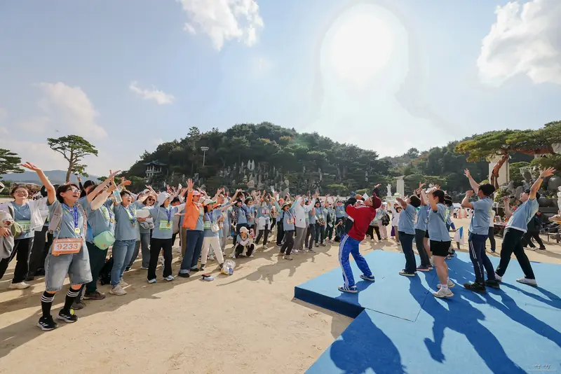 완주 메달을 걸고 무대 앞에서 함께 환호하는 참가자들