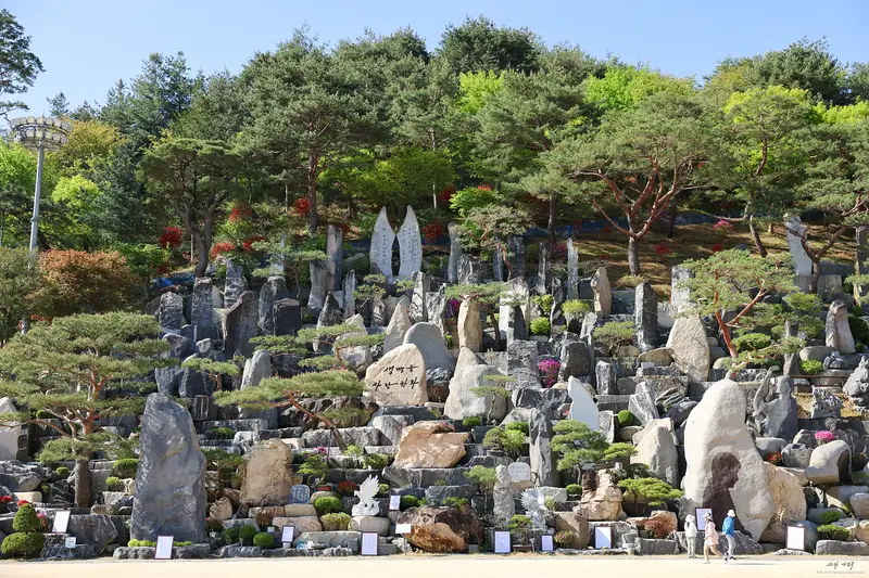 월명동 돌조경 앞에 놓인 시 액자와 가족 관람객